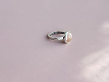 Load image into Gallery viewer, Pink stone ring set in sterling silver on a pink background.